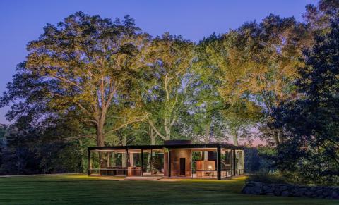 Image of The Glass House at nightfall illuminated lightly from inside