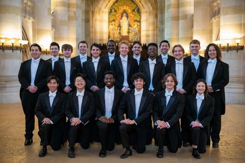 Group of diverse college students dressed in white tie and tails in two rows, back row standing and front row kneeling